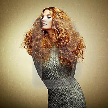 Portrait of beautiful woman in knitted dress. Fashion photo. Redhead girl