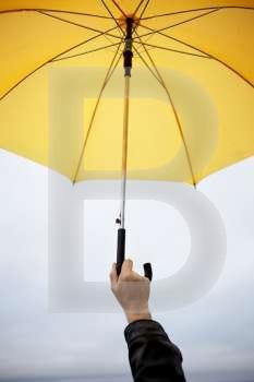 hand of man with yellow umbrella, selective focus on fingers (great abstract photo for many subjects)