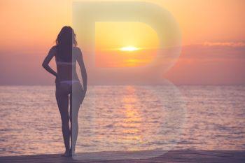 Woman silhouette over ocean sunrise background