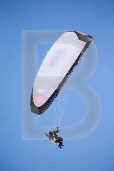 A paraglider isolated against a deep blue sky