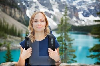 Portrait of attractive female hiker with her backpack against scenic view