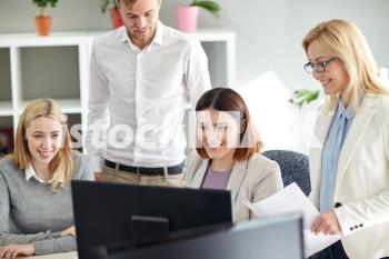 business, startup and people concept - happy creative team with papers and computer in office. happy business team with computer in office