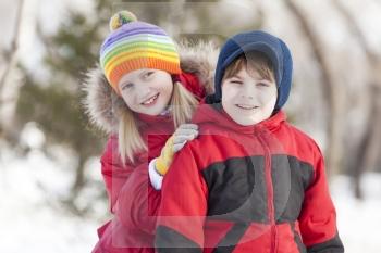 Cute girl and boy having fun in winter park. Winter activities