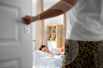 school, education and laziness concept - close up of parent opening door to kid’s room and tired teenage student girl with notebooks sleeping on bed at home. parent looking at student girl sleeping at home
