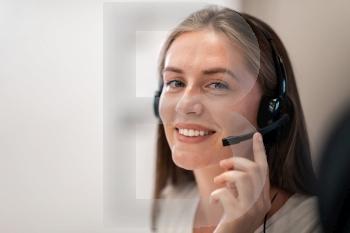 Helpline female operator with headphones in a call center.Business woman with headsets working in a call center. Selective focus. High-quality photo. Helpline female operator with headphones in call centre.Business woman with headsets working in a call center. Selective focus 