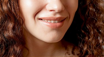 Close up shoot of young beautiful girl with perfect skin: makeup mouth zone. Smiling Lips.