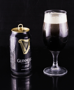 July 6, 2016: Guinness beer can and glass over black reflecting background. Guinness is an Irish dry stout produced by Diageo that originated in the brewery of Arthur Guinness at St. James&rsquo;s Gate, Dublin. Guinness is one of the most successful beer brands worldwide