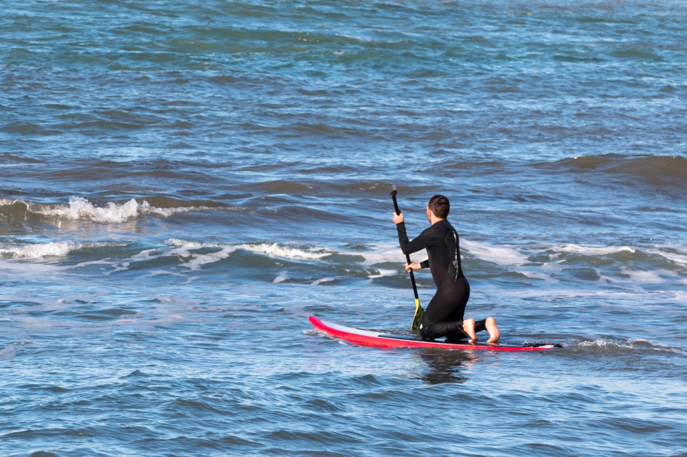 man paddleboarding on red board