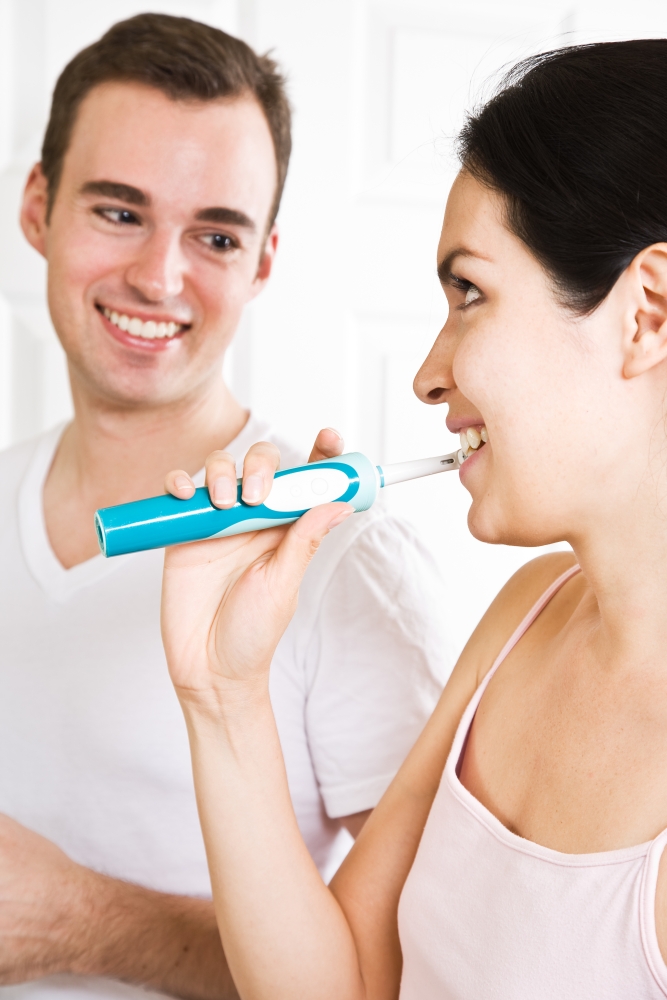 A beautiful interracial couple in the bathroom brushing teeth