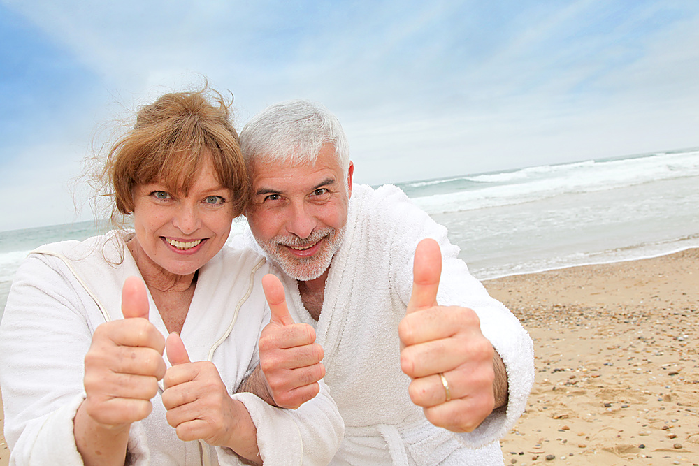 Happy senior couple on spa resort beach
