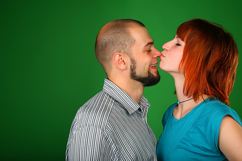Girl with red hair kisses guy on nose