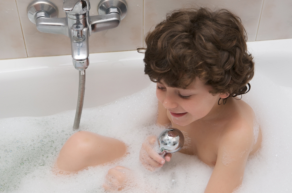 Small child happy and smiling in the bath