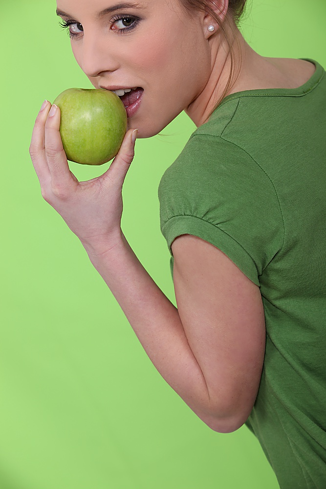 Woman biting green apple