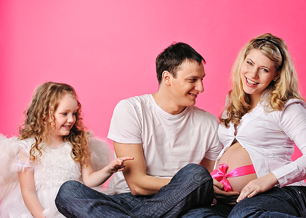 Portrait of a happy young family expecting a baby