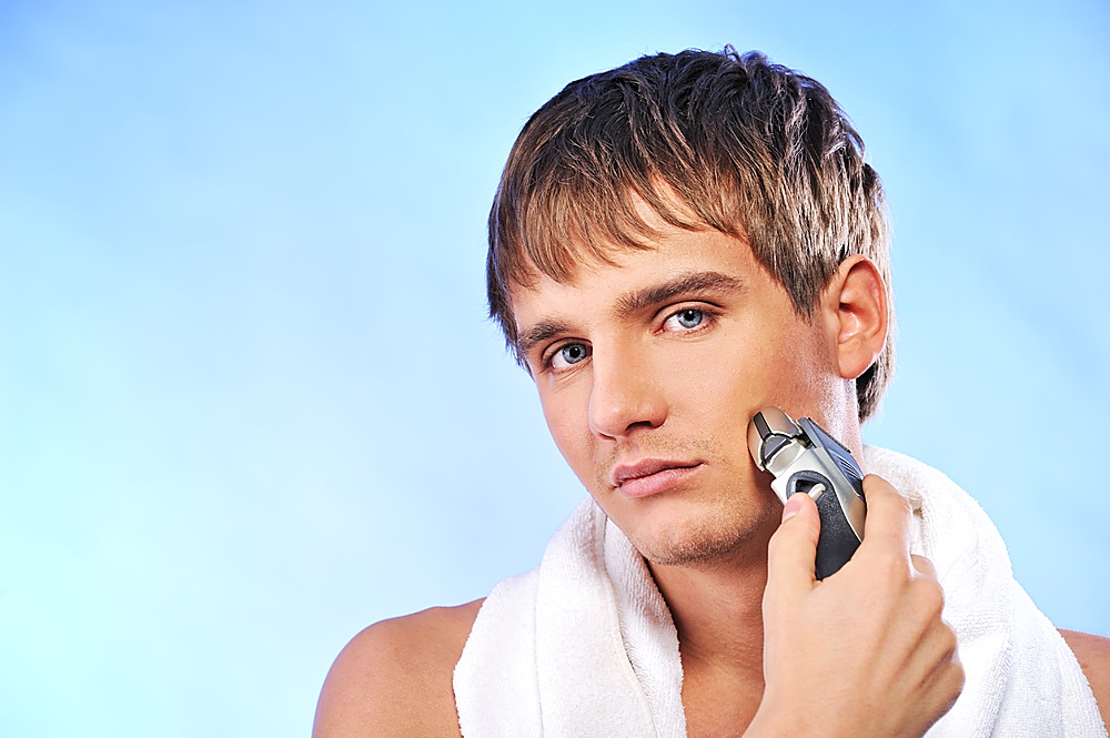 Handsome young man shaving
