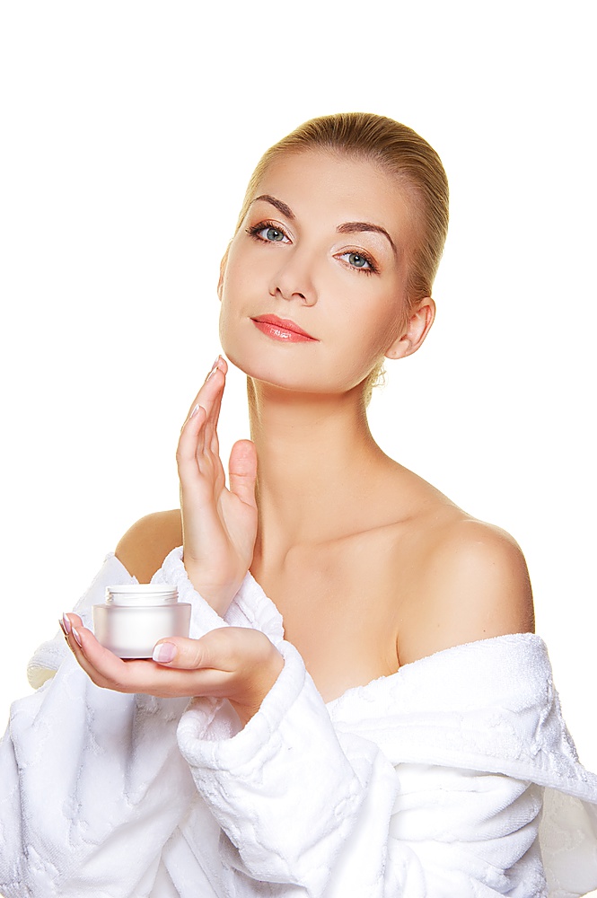 Woman applying moisturizer cream on her face