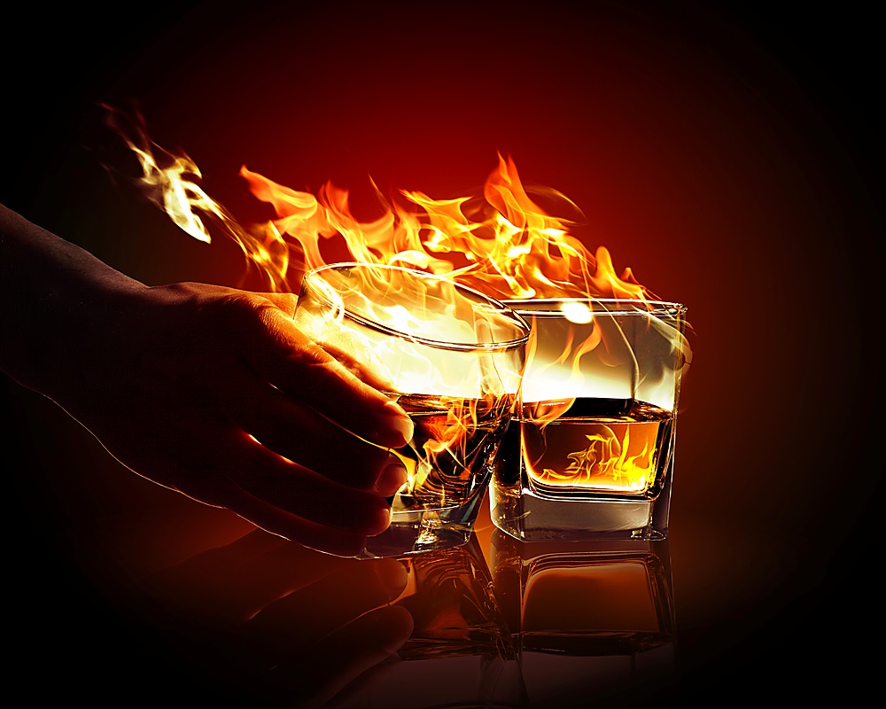 Image of two glasses of burning yellow absinthe