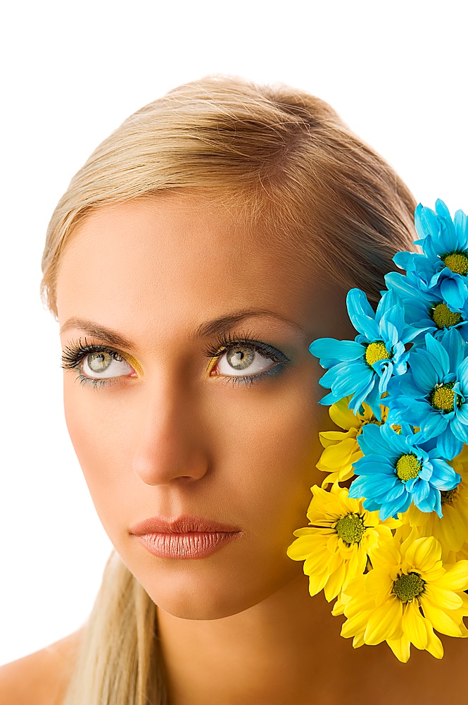beauty portrait of pretty young blond girl with blue and yellow daisy and colored makeup