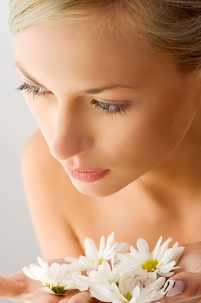 sweet beauty close up portrait of beautiful woman with some white daisy on hand