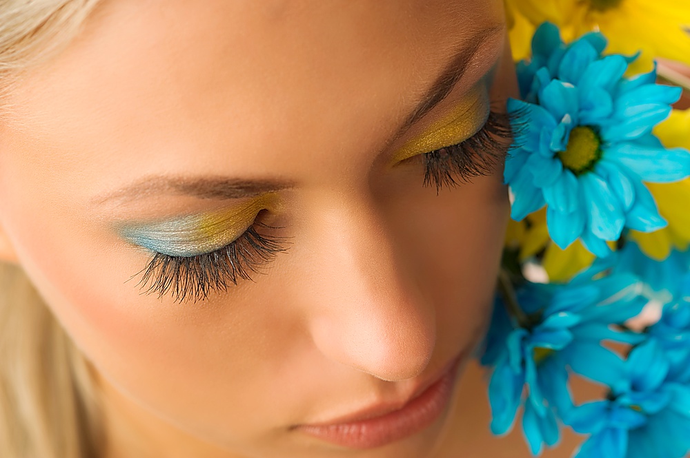 nice beauty portrait of pretty blond girl with blue and yellow daisy and colored makeup
