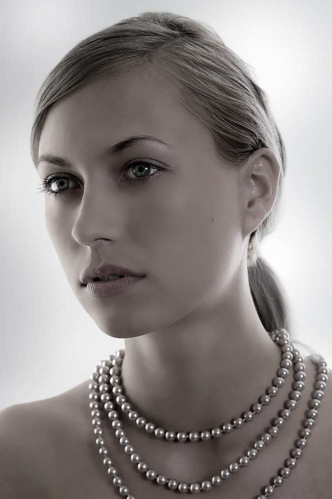 elegant and attractive woman with pearl necklace in a desaturate shot