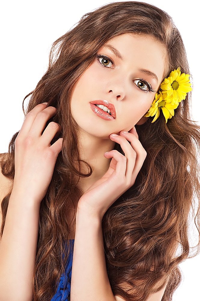 fresh portrait of a young cute girl with long hair and some yellow flower in it