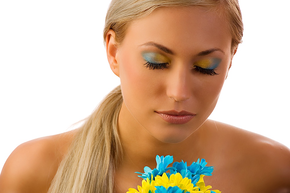 cute young woman with closed eyes and colored make up and daisy