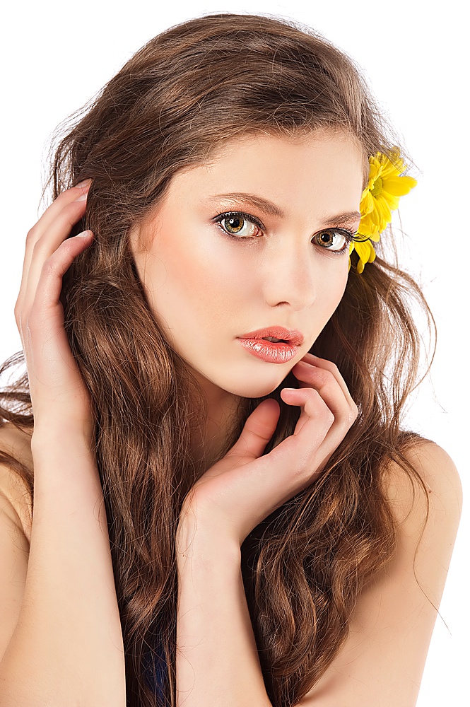 Beautiful fashion portrait of a young and fresh woman with yellow flowers in hair
