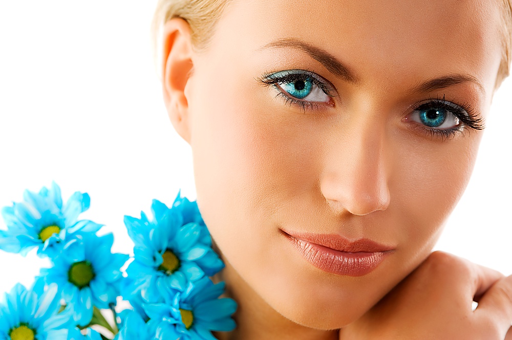 close up of a cute woman with big eyes and blue daisy