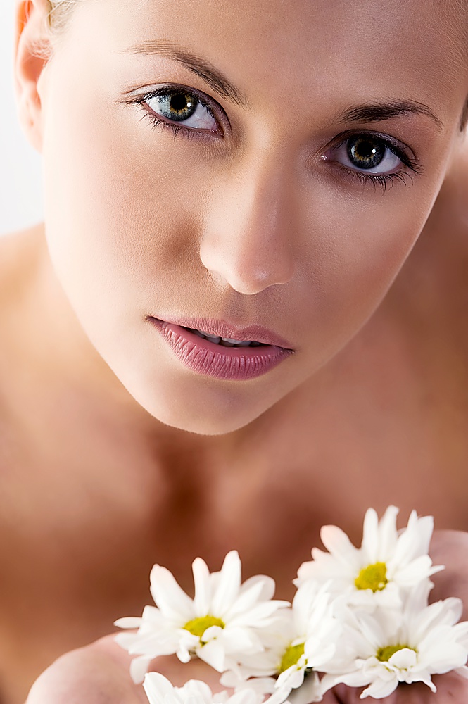 close up of beautiful woman with big eyes and some white daisy