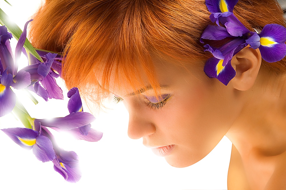 beauty portrait of a young woman with purple make up and flower