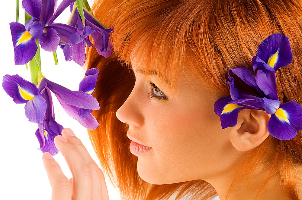 beauty portrait of cute redhead girl looking purple flowers