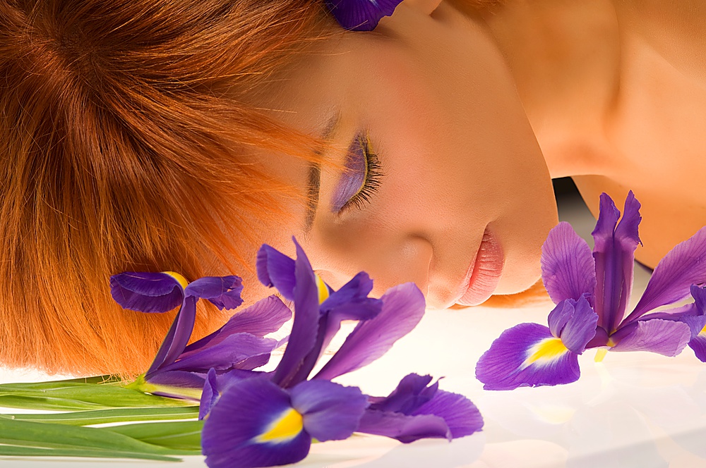 close up of young woman sleeping between violet flower