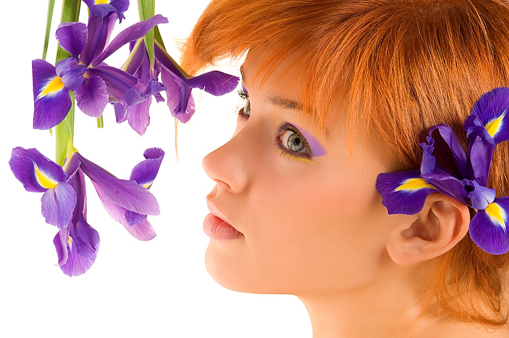 fresh portrait of nice young redhead laying near violet flower