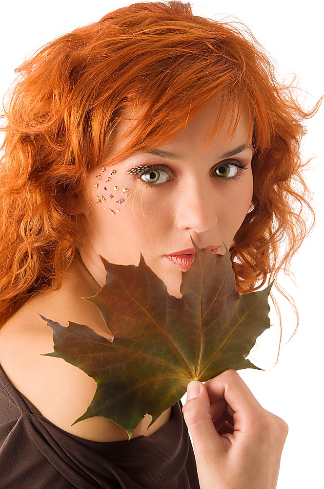 cute red haired girl with an autumn leaf