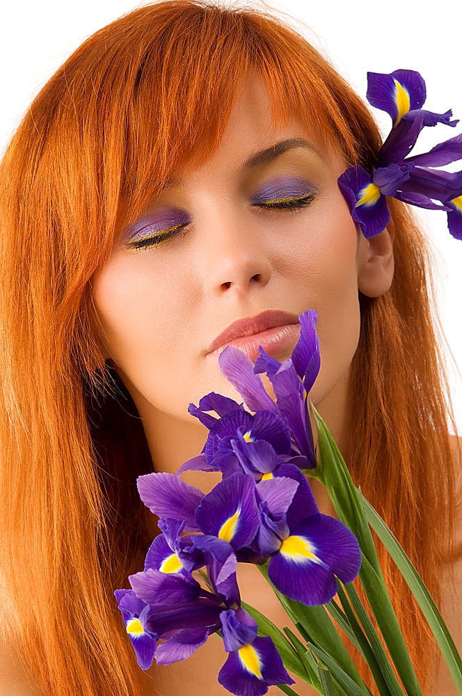 sweet portrait of a young pretty woman smelling purple flowers