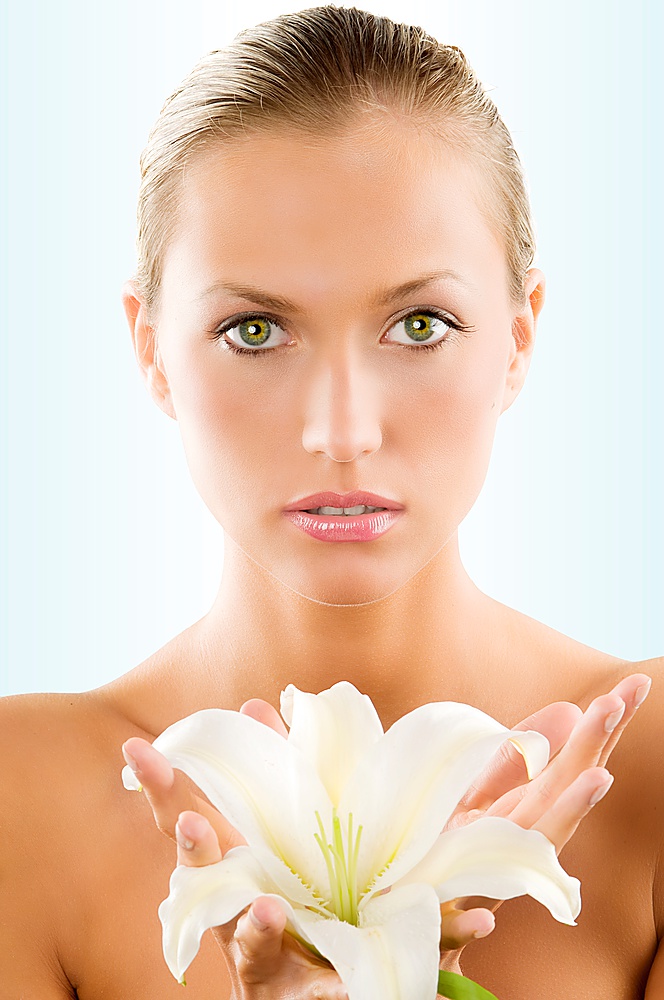 fresh portrait of a young and beautiful woman with a white lily and wet hair