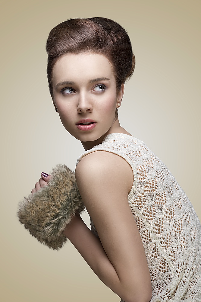 pretty young girl in fashion portrait with creative hair-style, pretty make-up and fur accessory in the hands