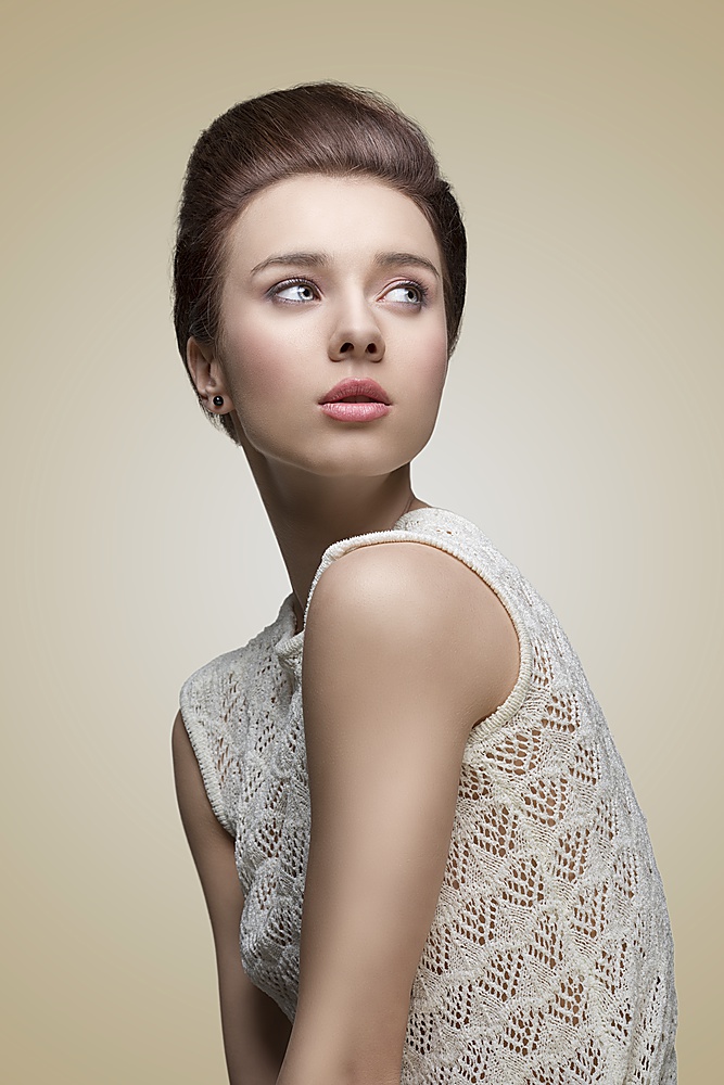 portrait of sensual girl with brown creative hair-style and pretty make-up in elegant pose.