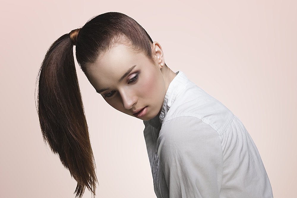 sensual young girl with brown ponytail hairstyle on the right, pretty make-up  wearing white shirt