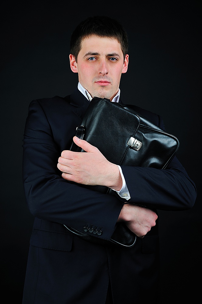 Businessman in a suit holds a briefcase