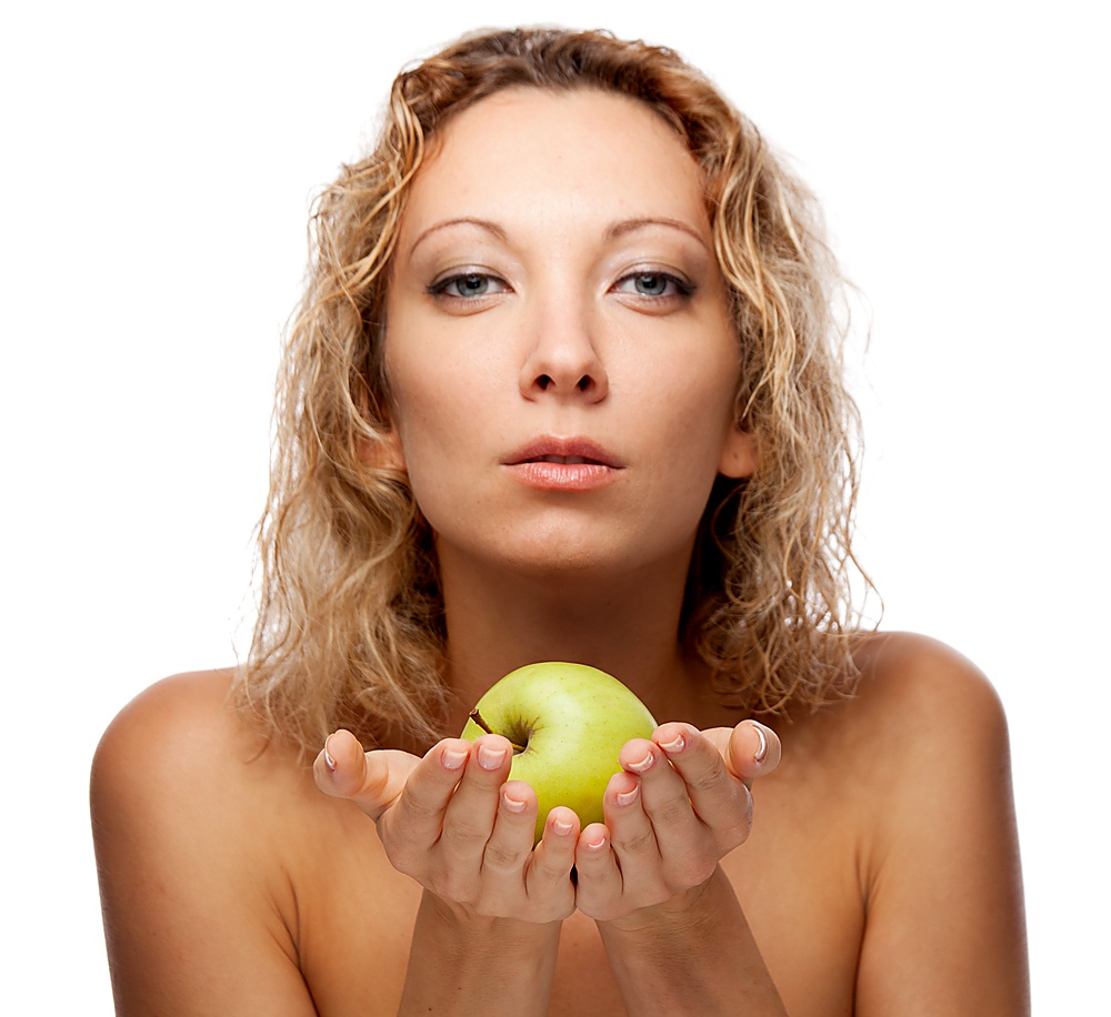Beautiful woman isolated over white. Focused on apple.