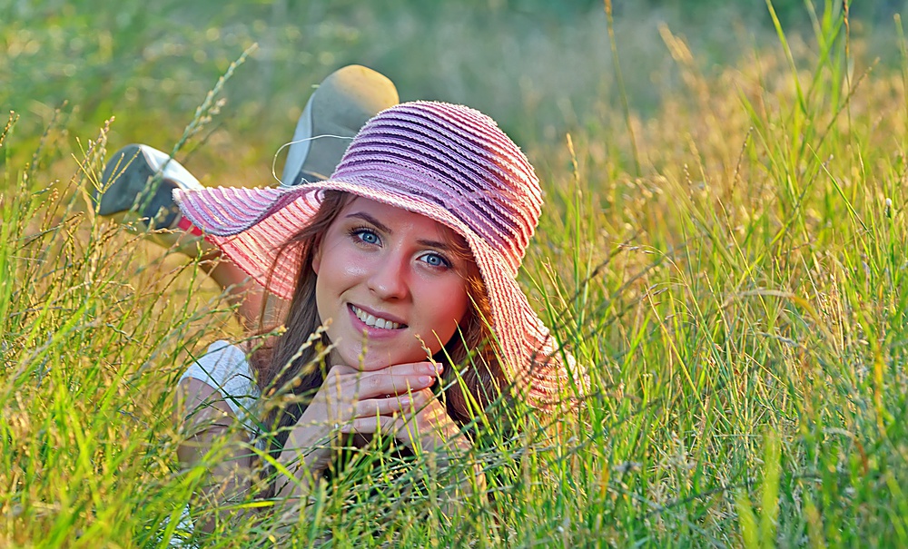 young beautiful girl lying on the green grass