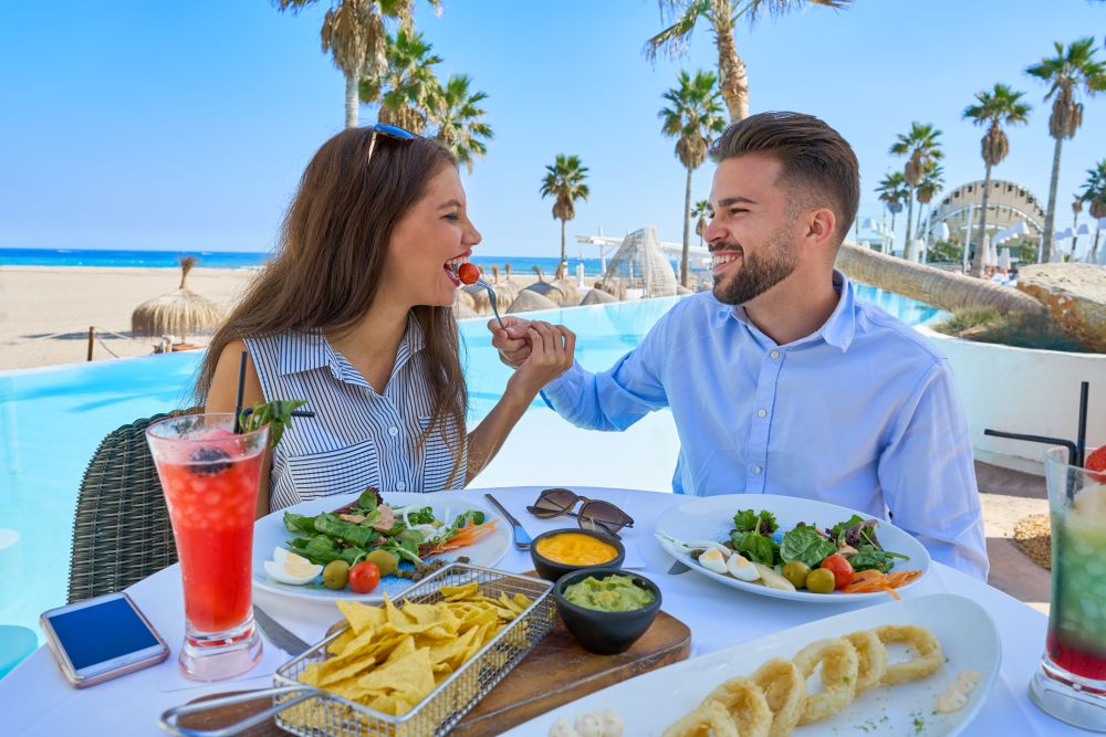 Young couple eating in a swimming pool restaurant