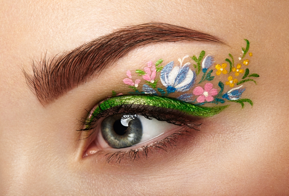 Eye makeup girl with a flowers. Spring makeup. Beauty fashion. Eyelashes. Cosmetic Eyeshadow. Make-up detail. Creative woman holiday make-up