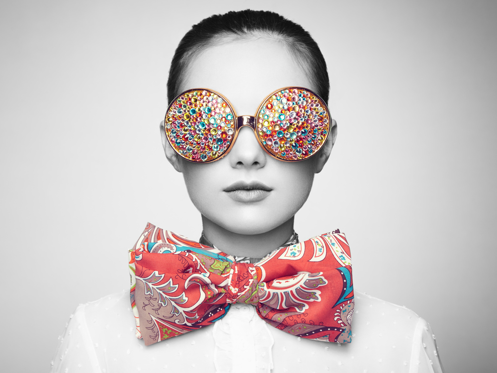 Portrait of beautiful young woman with colored glasses. Beauty fashion. Perfect make-up. Colorful decoration. Jewelry