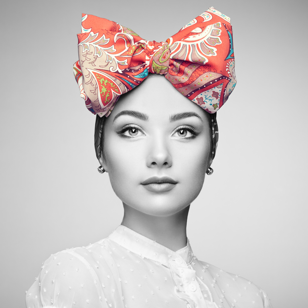 Portrait of beautiful young woman with bow. Brunette girl. Beauty fashion. Cosmetic make-up