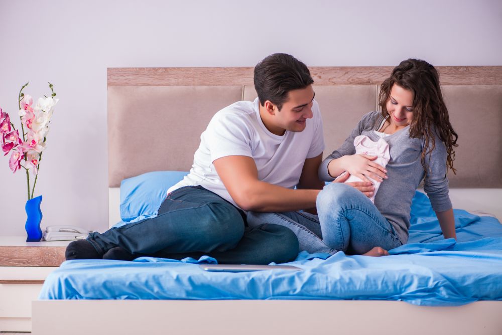 Young family with pregnant wife expecting baby in bed