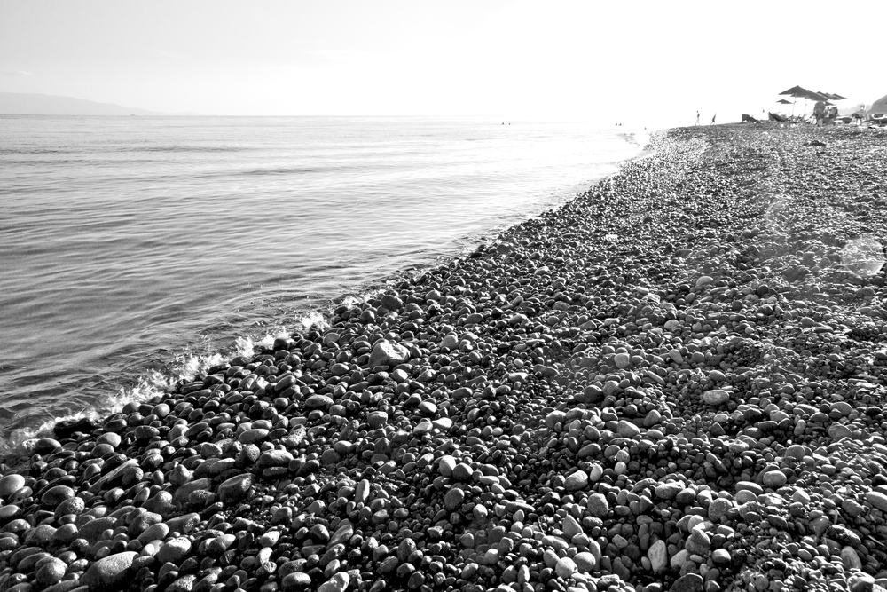 stone in the coastline sunrise and light ocean     white sky