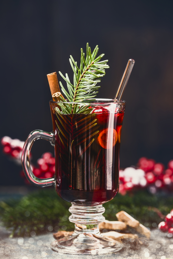 Mulled wine in glass mug with winter spices , front view